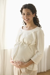 Pregnant woman, with hands beneath belly