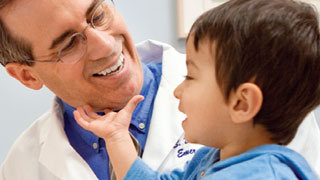 smiling child touching doctor's chin