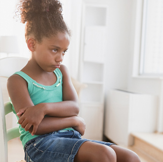 Little girl sitting in a chair with her arms crossed refusing to move.