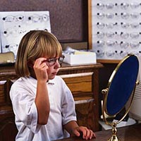 Imagen de una niña probándose un par de anteojos.