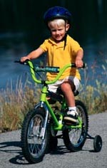 Fotografía de un niño, con casco, andando en bicicleta.