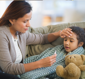 Mother with her hand on child's forehead, reading a thermometer