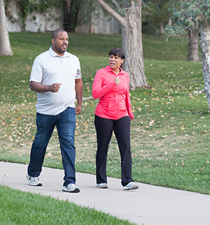 Exercise is the best medicine for your body. Work with your healthcare provider to set up a program that works for you. Man and woman walking in park.