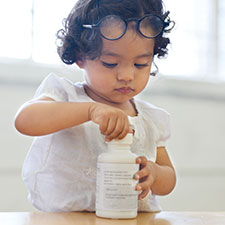 baby holding medicine bottle