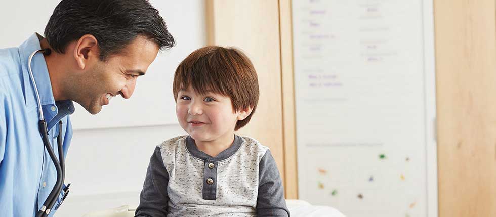 Doctor with stethoscope and boy smiling