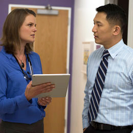 woman with tablet talking to man