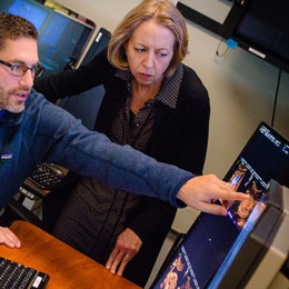 professionals pointing to computer