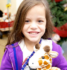 Girl holding a stuffed giraffe toy
